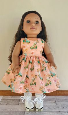 an american girl doll wearing a dress and white shoes, standing in front of a wall