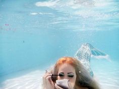 a woman with long hair and makeup in the water