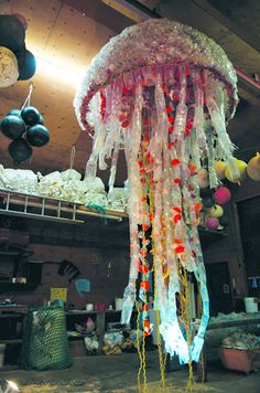 a large jellyfish hanging from the ceiling in a room filled with balloons and streamers