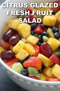 a fruit salad in a white bowl with the words citrus glazed and fresh fruit salad