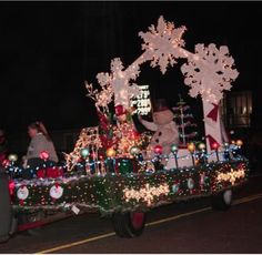 a parade float decorated with christmas lights and decorations