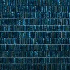 blue glass mosaic tiles are arranged in rows on the wall, and one is very dark