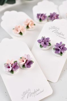 small purple and pink flowers are on top of white cards