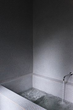 a white bath tub sitting inside of a bathroom next to a faucet and shower head