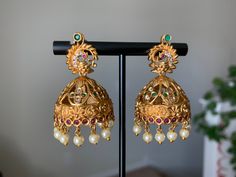 Gold Temple Golden Matte Jhumka. Handcrafted pair of earrings. Gives a traditional look. Indulge in it or gift it and watch the compliments flow! Can be worn for engagement and wedding parties. Height: 2 inch Width: 1 inch It is advisable to store jewelry in a zip lock pouch (air tight pouch), keep away from water perfume and other chemicals and clean it with soft cloth.Ethnic Wear. Pakistani Earrings, Gold Jhumka, Jewelry Ruby, Peacock Earrings, Earrings Indian, Wedding Parties, Ruby Earrings, Indian Jewelry, Jewelry Earrings Dangle