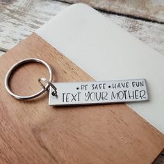 a metal keychain that says pet safe have fun text your mother on it