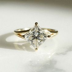 a gold ring with a princess cut diamond