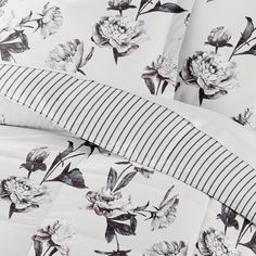 the comforter is made up with flowers and stripes on it's bedding