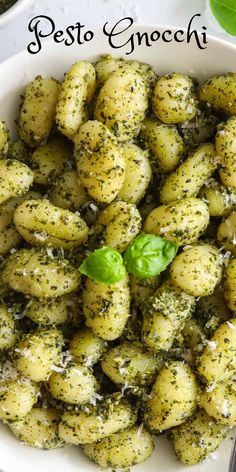 pesto gnocchi in a white bowl with basil sprinkled on top