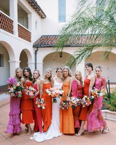 a group of women standing next to each other in dresses and holding bouquets on their laps