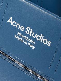 Acne Studios' tote is made from crisp shell that has a paper-like texture and smooth leather printed with the brand's logo. Use the front pocket to keep your cardholder close to hand and the main compartment for everything else. Blue Shoulder Bag With Logo And Double Handles, Blue Double Handle Shoulder Bag With Logo, Modern Shoulder Bag With Embossed Logo For Daily Use, Blue Leather Bags With Logo, Modern Travel Shoulder Bag With Embossed Logo, Blue Top Handle Shoulder Bag With Logo, Blue Top Handle Bag With Logo, Everyday Blue Bags With Logo, Modern Everyday Bags With Logo Tag