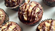 there are many cupcakes with chocolate drizzled on them