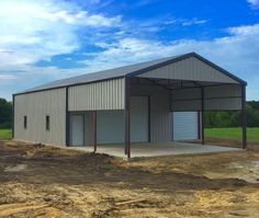 a large metal building sitting on top of a dirt field