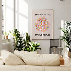 a living room filled with lots of plants next to a wall mounted art piece that reads, this way to the dance floor