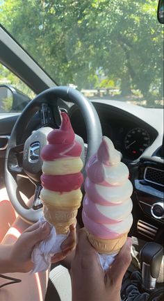 two ice cream cones sitting on top of each other in front of a steering wheel