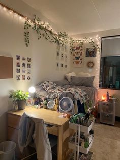 a dorm room with a bed, desk and various items on the table in front of it