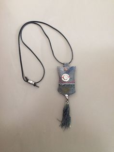 a small bag with a tassel hanging from it's side on a cord