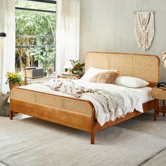 a bed sitting in a bedroom next to a window with plants on top of it