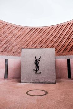 the monogramic logo on the side of a building in front of a red roof