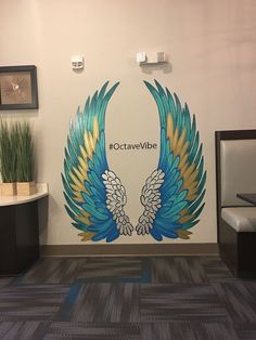 an office lobby with a large mural depicting two blue and yellow wings