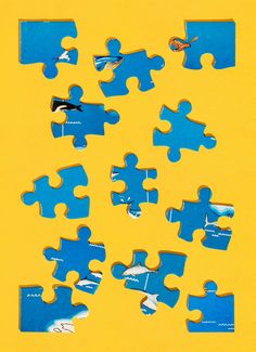 several pieces of blue puzzle sitting on top of a yellow surface