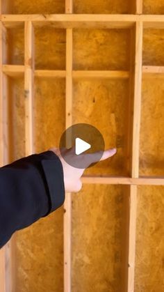 a person pointing to the ceiling in a room that is being constructed with plywood