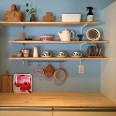 the shelves are filled with dishes and other kitchen items, including tea kettles and cups