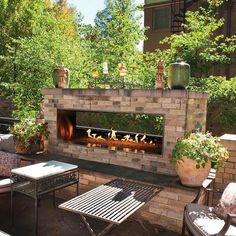 an outdoor fireplace with chairs and tables around it