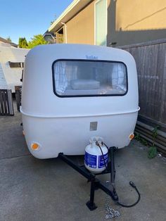 an rv is parked in the driveway with a spray can on it's side