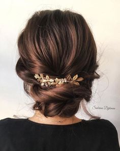 a woman wearing a hair comb with flowers on it's head and her hair in a low bun