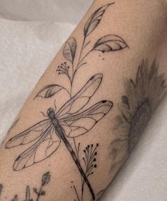 a black and white photo of a dragonfly on the arm