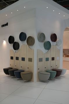 several hats are hanging on the wall in front of a white room with tile flooring