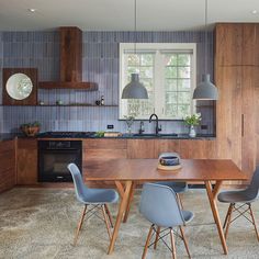 a kitchen with a table and chairs in the middle of it, next to a stove top oven