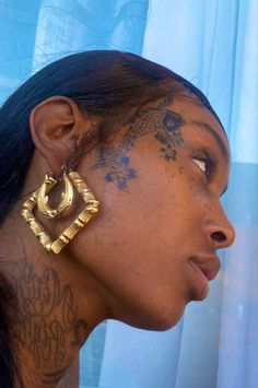 a woman with tattoos on her face and ear