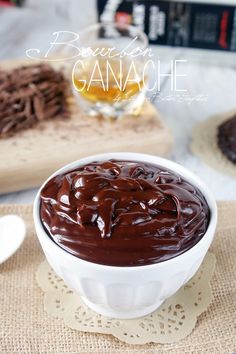 a white bowl filled with chocolate ganache on top of a table