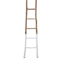 an old wooden ladder leaning up against a white wall