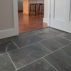 an open door leading to a kitchen with stools and counter tops in the background