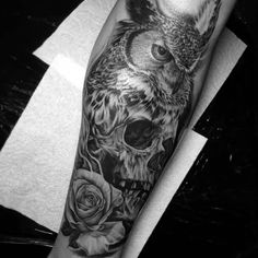 an owl and roses tattoo on the arm