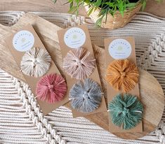 four small pieces of yarn sitting on top of a wooden board next to a potted plant