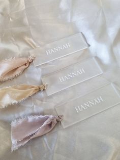 three pieces of cloth with the names hannah and hannah written on them sitting on a white sheet