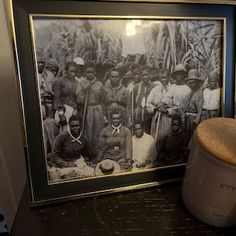 a black and white photo with a drum in front of it on a table next to a framed photograph