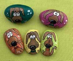 four painted rocks with cartoon dogs on them