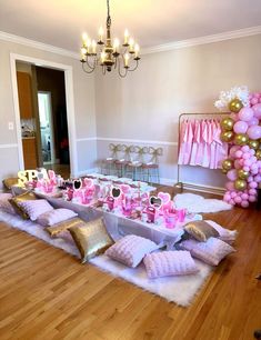 a party table set up with pink and gold decorations