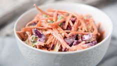 a white bowl filled with coleslaw on top of a table