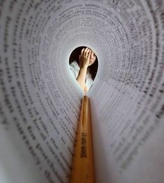 a woman is looking through a hole in a book