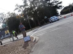 a man standing on the side of a road next to a street sign