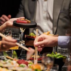 people are eating sushi and chopsticks at a table