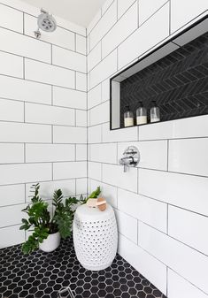 a black and white tiled bathroom with potted plants