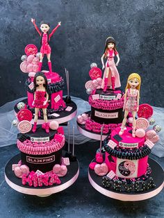 three tiered cakes decorated with barbie dolls on top of each other in pink and black