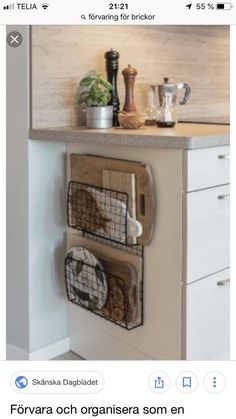 a kitchen with white cabinets and wooden counter tops, two metal baskets on the wall